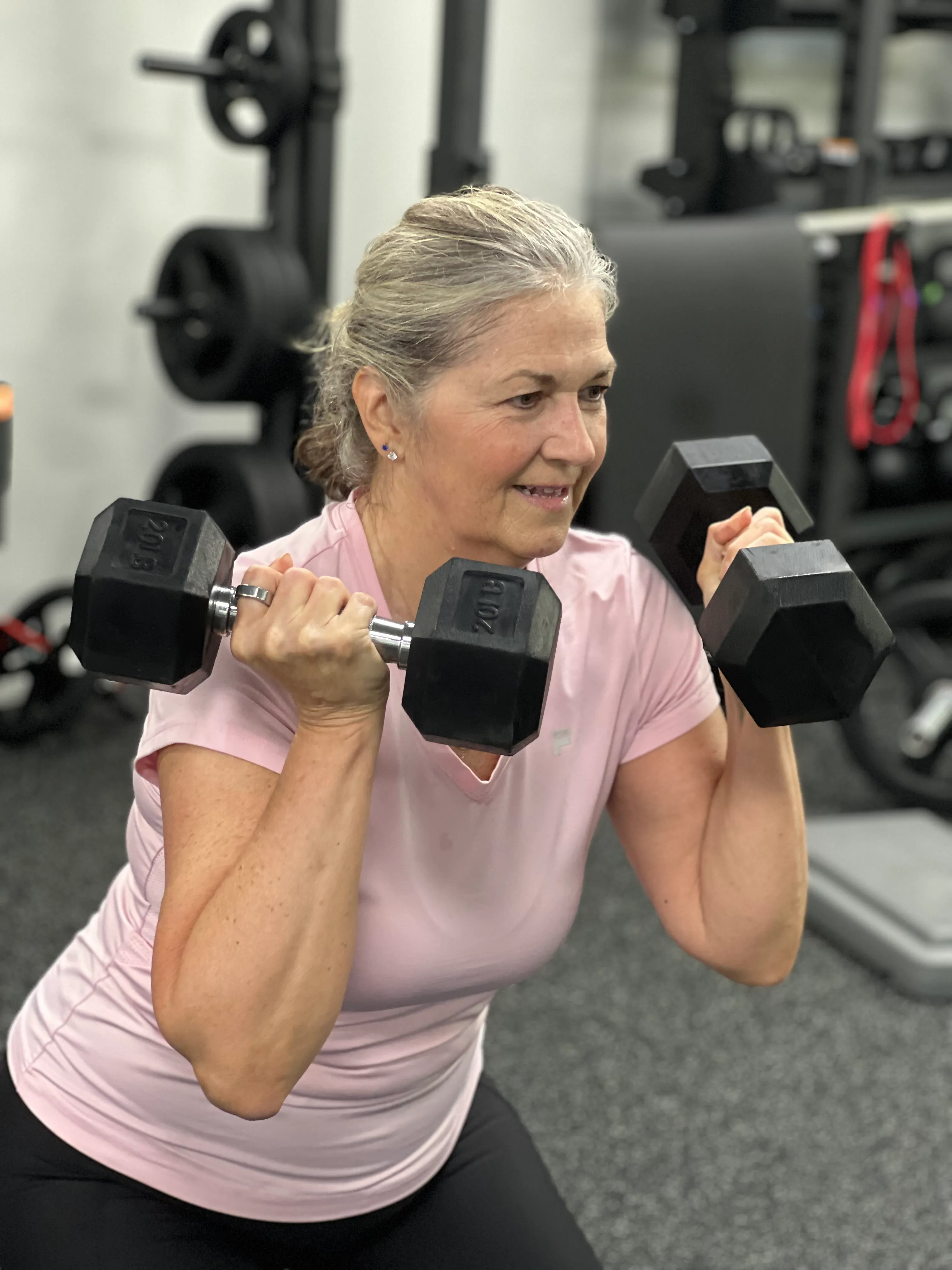Member performing overhead dumbbell press at Next Gen