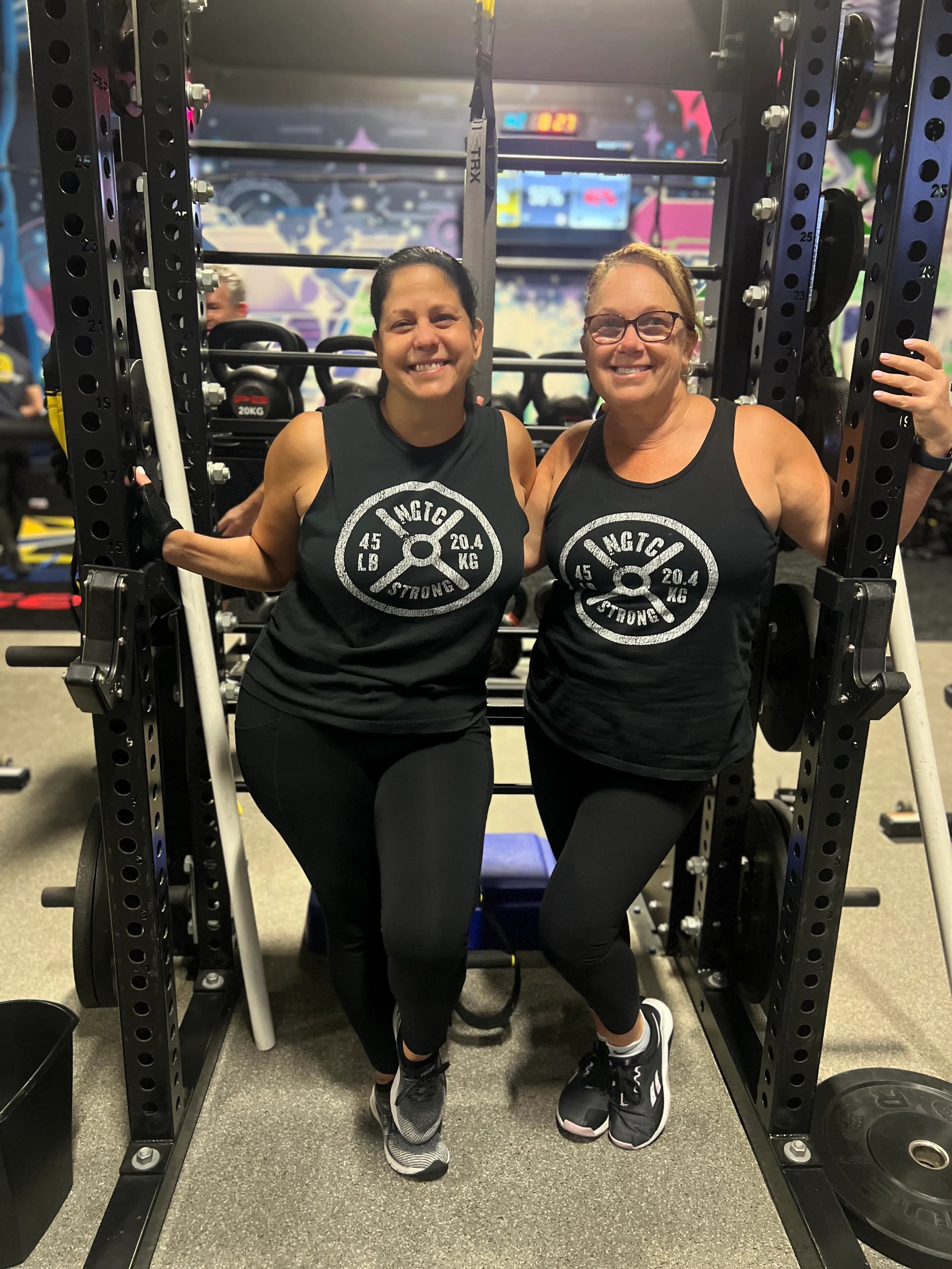 Members posing strong in the power rack at Next Gen